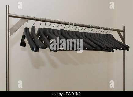 Row of black plastic coat hangers Stock Photo