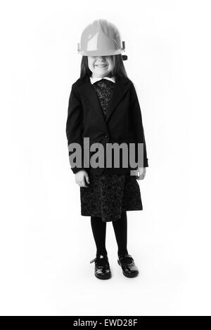 standing young girl wearing a hard hat far to big for her head Stock Photo