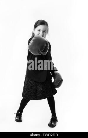 young girl dressed up as a business person wearing boxing gloves Stock Photo