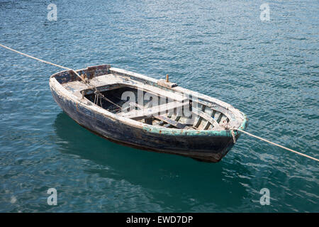 Old wooden rowing boat tied up in a harbor harbour in Turkey at both stern and bow