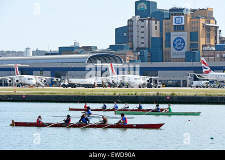 Airplane at London City Airport rowers training in old Royal Docks next to runway London Docklands Newham England UK with Tate & Lyle sugar refinery Stock Photo