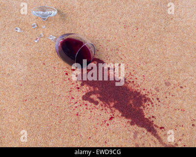 glass of red wine dropped on the carpet Stock Photo