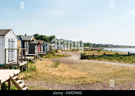 Row of wooden beach huts along Whitstable beach Stock Photo