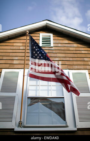 American flag blows in the wind on a façade of a building in Rockport, Massachusetts. Stock Photo