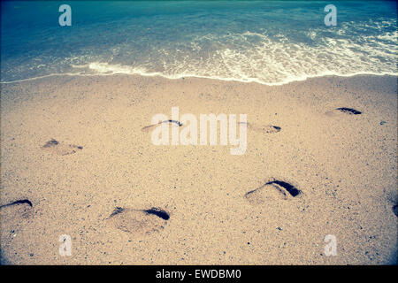 Footsteps in the sand at the beach - retro styled photo Stock Photo