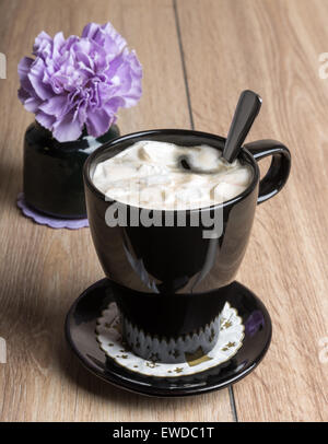 Coffee with marshmallows in a black mug on the wooden table Stock Photo