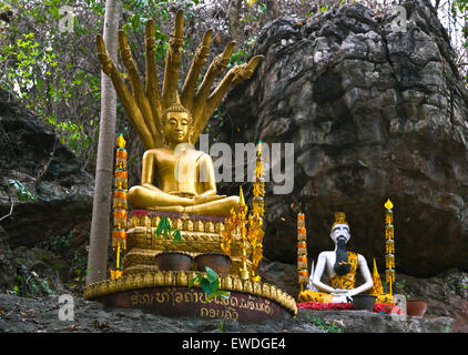 GOLDEN BUDDHA and meditating BUDDHIST SAINT on MOUNT PHOUSI  - LUANG PRABANG, LAOS Stock Photo