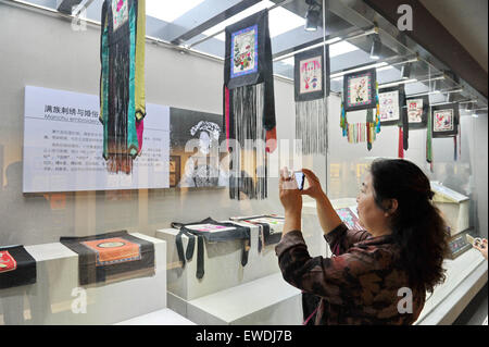 Changchun, China's Jilin Province. 24th June, 2015. A visitor takes photos of artworks of Man ethnic group during an Man embroidery exhibition in Changchun, capital of northeast China's Jilin Province, June 24, 2015. Credit:  Zhang Nan/Xinhua/Alamy Live News Stock Photo