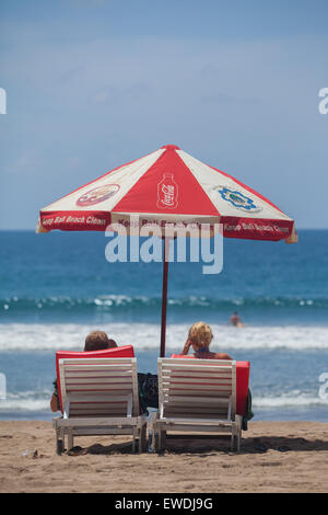 Tourists enjoying sunny day in Kuta beach, Bali. Stock Photo