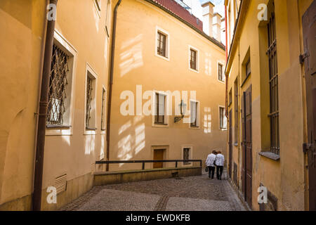 Senior friends, rear view of two senior women walking along a typical street in the medieval center of the historic Stare Mesto district in Prague. Stock Photo
