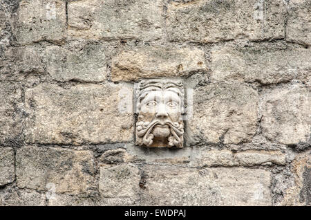 Stone face hand carved in Bath Stone on a wall in Walcot Street Bath one of more than 30 grotesques on display Stock Photo
