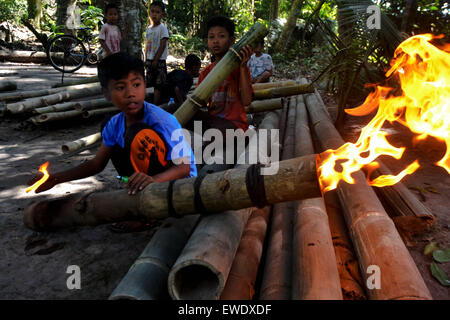 Yogyakarta, Indonesia. 24th June, 2015. Children playing bamboo cannon wait to break their fast on the holy month of Ramadan in Yogyakarta, Indonesia, June 24, 2015. Playing bamboo cannon during Ramadan is a tradition in some region of Indonesia. Credit:  Oka Hamied/Xinhua/Alamy Live News Stock Photo