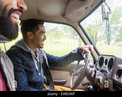 Two young men in a car, driver and passenger, smiling Stock Photo