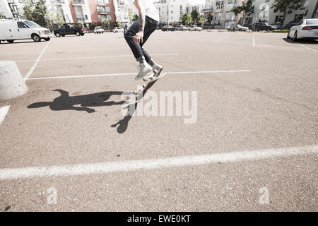 Young man skateboarding in a car park Stock Photo