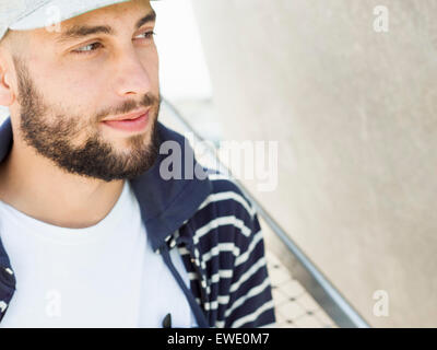 Portrait of a smiling young man beard Cap looking sideways Stock Photo