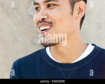 Portrait of a smiling young man Asian mixed race stubble beard looking sideways Stock Photo