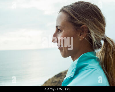 A smiling young woman, side profile, in a blue running top Stock Photo