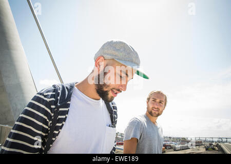 Two young men walking along a footbridge city life Stock Photo