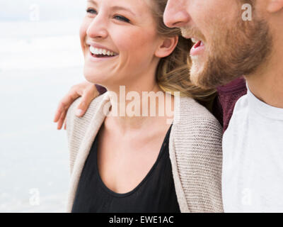 Close up of a smiling young man and young woman on a beach Stock Photo
