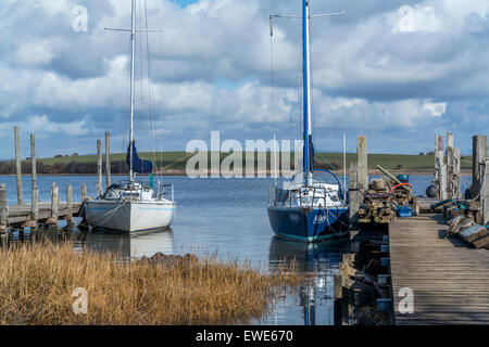 Two yachts moored along the jetties no sails, cloudy sky, sea, Stock Photo