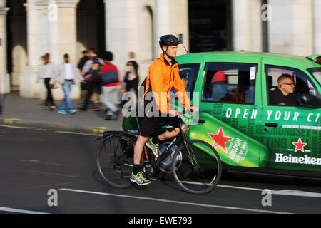 A cyclist and taxi traveling around Trafalgar Square, London, England Stock Photo