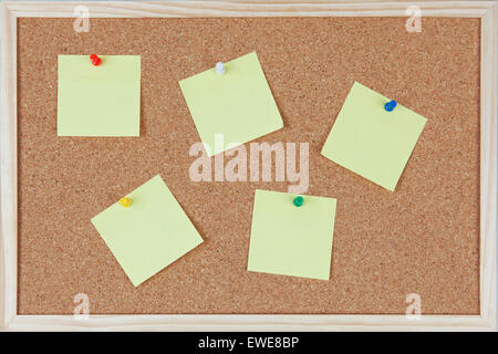 Five post-it notes with pins sticked on corkboard Stock Photo