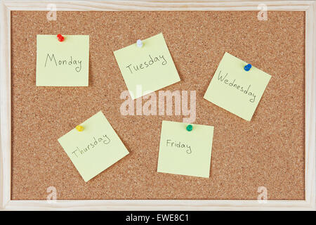 Post-it notes with weekdays sticked on corkboard. Stock Photo