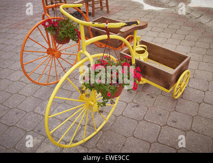 Ornamental penny farthing tricycles planters, with trugs on display in Fethiye's old town, Turkey. Stock Photo