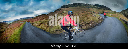 270 degree view of cyclist riding up Hardknott Pass in Cumbria. Stock Photo