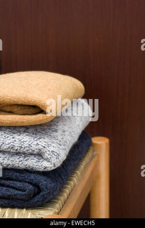 pullovers on chair Stock Photo