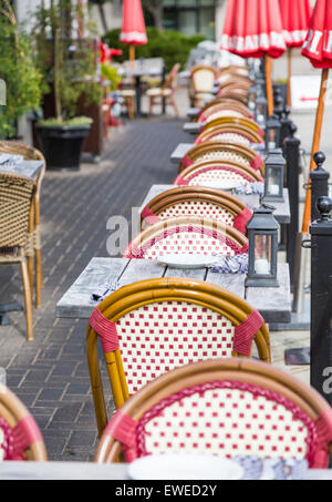 Wicker chairs and wood tables at an outdoor restaurant patio Stock Photo