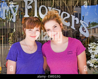 Two pretty teen-aged girls, who are sisters, stand in front of their grandmother's store in a small town in northern Oregon. Stock Photo