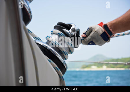 Winch and sailors hands on a sailboat. Shot with a selective focus Stock Photo