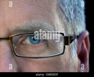 Half face mature male business man close up with glasses featuring left blue eye Stock Photo