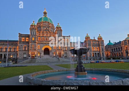 Illuminated fountain in front of the British Columbia Parliament buildings at twilight in the Inner Harbour in the city of Victo Stock Photo