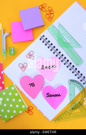 Back to School or Education Concept with stationery and desk accessories overhead on bright yellow background. Stock Photo