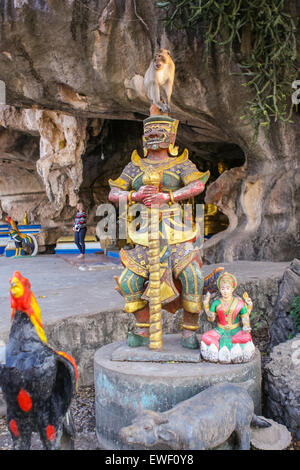 Monkey seats on the buddist statue. Thailand. Stock Photo