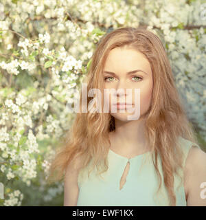 Beautiful girl in the spring blooming garden Stock Photo