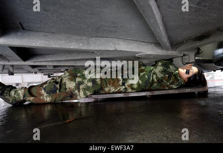 (150625) -- DEHONG, June 25, 2015 (Xinhua) -- Zhang Liu checks the bottom of a car for contraband at the border checkpoint of Mukang in Dehong Dai-Jingpo Autonomous Prefecture, southwest China's Yunnan Province, June 24, 2015. Born in 1995, Zhang Liu became an anti-drug soldier in border checkpoint of Mukang in 2013.  Grown up in an affluent family in central China's Hunan Province, Zhang said that being a soldier had always been her dream, which drove her to join the army after graduating from high school. Being a front line anti-drug force, the border checkpoint of Mukang has captured about  Stock Photo