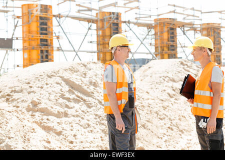 Side view of supervisors discussing at construction site Stock Photo