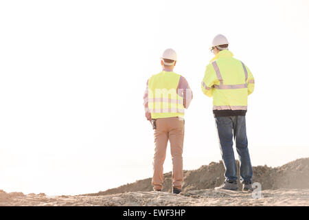 Rear view of architects standing at construction site against clear sky Stock Photo