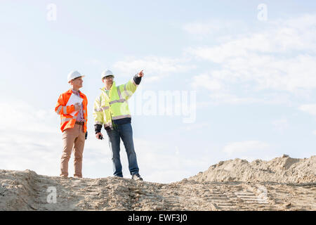Low angle view of supervisor showing something to colleague at construction site Stock Photo