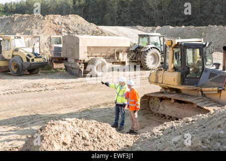 Supervisor showing something to colleague at construction site Stock Photo