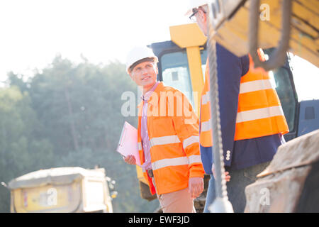 Supervisors discussing at construction site on sunny day Stock Photo