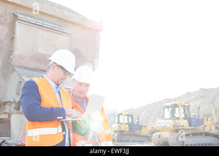 Engineers using laptop at construction site against clear sky Stock Photo