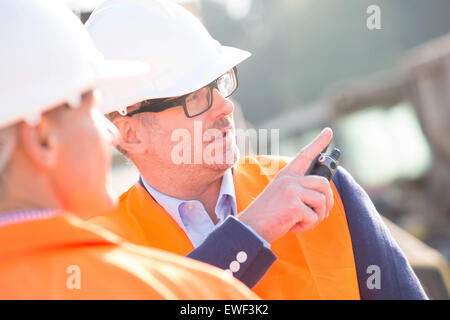 Supervisor showing something to colleague at construction site Stock Photo