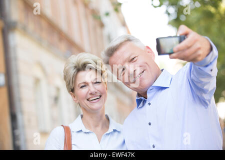 Cheerful middle-aged couple taking self portrait outdoors Stock Photo