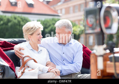 Romantic middle-aged couple sitting in horse cart Stock Photo