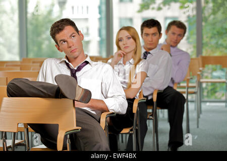 Business executives sitting in row at office Stock Photo