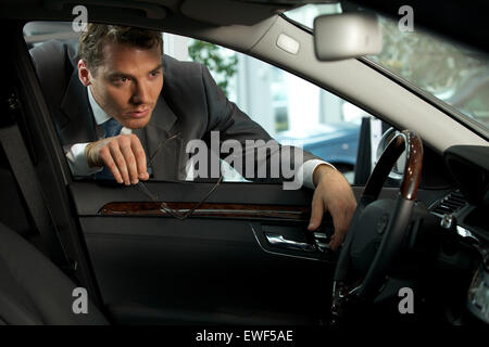 Man looking at new car in showroom Stock Photo